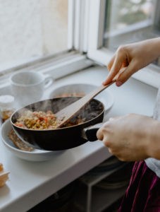 person cooking with a pan