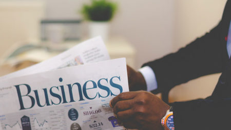 person reading business section of a newspaper